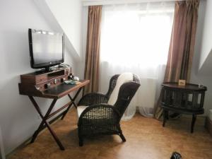 a room with two chairs and a television on a table at Stadtvilla Auerhahn in Vöcklabruck