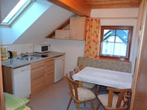 eine kleine Küche mit einem Tisch und einem Waschbecken in der Unterkunft Haus Edelweiss in Sankt Margarethen im Lungau