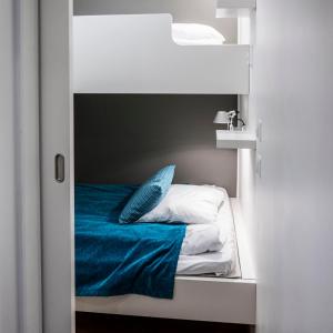 a bunk bed with a blue blanket and pillows at Vuokatti Sport Chalets in Vuokatti