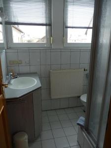 a bathroom with a sink and a toilet and two windows at Ferienwohnungen an der Obermaintherme in Bad Staffelstein +32 photos