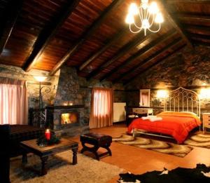 a large bedroom with a bed and a fireplace at Grand House Suites in Palaios Agios Athanasios