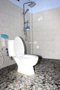 a bathroom with a toilet with a shower and a shower at Danke Lodge in Labuan Bajo