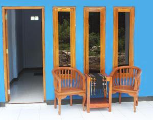 two chairs and a table in front of two mirrors at Danke Lodge in Labuan Bajo
