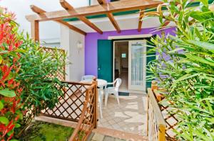a balcony with a table and chairs and plants at Villaggio Margherita in Caorle