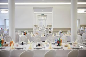 a room filled with white tables and chairs at Zajazd Podzamcze in Fałków