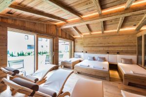 Pepi's Suites - Lechtal Apartments في هولزاغو: غرفة بجدران وكراسي خشبية ونافذة كبيرة