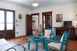 sala de estar con sillas azules y mesa en Hotel Resort Nuraghe Arvu, en Cala Gonone