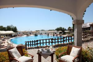 a view of a swimming pool with chairs and a table at Hotel Resort Nuraghe Arvu in Cala Gonone