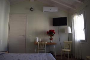 - une chambre avec un lit, une table et une télévision dans l'établissement Residenza Il Salice, à Bagnolo San Vito