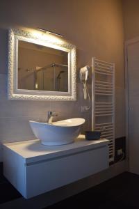 a bathroom with a white sink and a mirror at Residenza Il Salice in Bagnolo San Vito