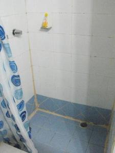 a bathroom with a shower with a blue tile floor at Hotel Laguna in Bocas Town +28 photos