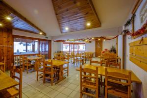 an empty restaurant with wooden tables and chairs at Village Le Grand Fourchon in Valmeinier