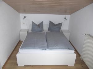 Cama en habitación pequeña con 2 almohadas en Buchenweg 40a, en Isenbüttel