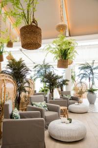 a room with a bunch of chairs and potted plants at LUX* Grand Gaube Resort & Villas in Grand Gaube