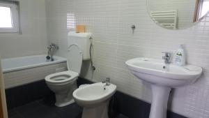 a white bathroom with a toilet and a sink at Family Pension in Arad