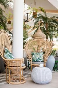 LUX* Grand Gaube Resort & Villas في غراند غايوب: غرفة مع كرسيين الخوص و مزهرية