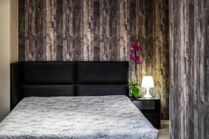 a bedroom with a bed and a wooden wall at Hi-Life Family Hotel in Novi Iskŭr