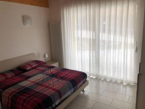 a bedroom with a bed and a large window at Casa Magosta in Malcesine