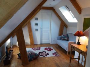 a attic room with a couch and a window at Les Trois Prunelles in Saint-Pierre-Toirac