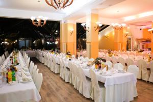 ein Bankettsaal mit weißen Tischen und weißen Stühlen in der Unterkunft Okulski Grand Rozewie Pokoje i Apartamenty in Jastrzębia Góra + 167 Fotos