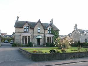 uma casa grande com um paisagismo em frente em Moraydale Guest House em Elgin