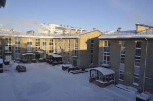 a group of buildings with snow in a parking lot at Guest House A-suite in Omsk
