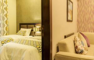 a hotel room with two beds and a chair at Shams Alweibdeh Hotel Apartments in Amman