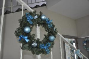 a christmas wreath with blue ornaments on a staircase at Guest House A-suite in Omsk