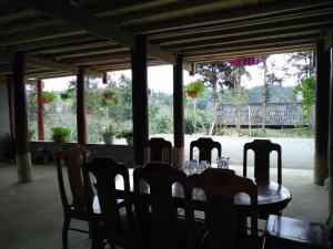 a table and chairs in a room with a window at Flower hmong homestay in Bắc Hà