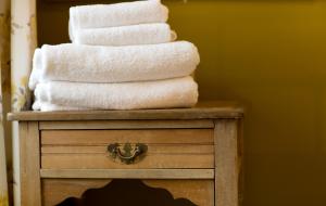 a stack of towels sitting on top of a dresser at Driftwood Cottage by Coast & Country Stays in Seahouses +26 photos