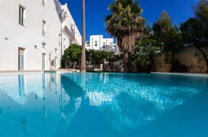 een groot blauw zwembad naast een gebouw bij Grand Hotel Di Lecce in Lecce