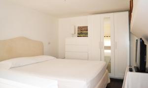 1 dormitorio blanco con 1 cama y TV en La Casa Di Anna B&B en Reggio Calabria
