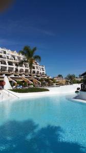 a swimming pool in front of a resort at Rocas del Mar Holiday in Costa Del Silencio