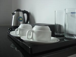 a black table with two cups and a plate and a glass at Marvelot Hotel in Kajang