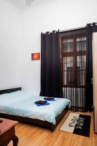 a bedroom with two beds and a window with black curtains at M Central Apartments in Cluj-Napoca