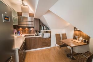 a kitchen with a wooden table and a kitchen with a sink at Horský apartmán Špindlerův Mlýn in Krausovy Boudy +11 photos