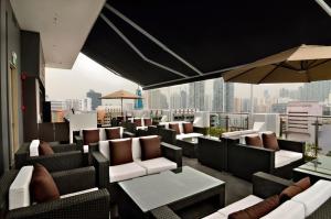 a rooftop bar with chairs and tables and a city skyline at The Seacare Hotel in Singapore