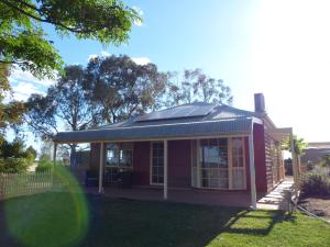 a small red house with a solar roof at Glenbar cottage Yelta in Mildura