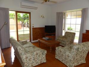 ein Wohnzimmer mit 2 Sofas und einem TV in der Unterkunft Glenbar cottage Yelta in Mildura