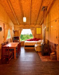 een slaapkamer met een bed, een bureau en een tafel bij Cabaña Nueva en Ancud Chiloe in Ancud