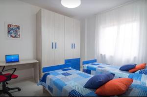 a bedroom with two beds and a desk with a computer at Maison Eva in Sorrento