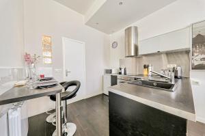 a kitchen with a sink and a counter top at Le Marnois-Centre Ville in Noisy-le-Grand