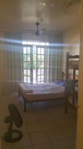 1 dormitorio con cama, ventana y silla en Casa em Porto Seguro, en Porto Seguro