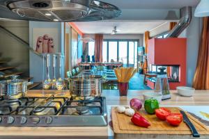 a kitchen with a stove and a cutting board with vegetables at Skinos Ilivatos Eco Villa & Estate in Chavriáta