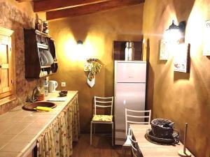 a kitchen with a refrigerator and a table and chairs at Mirador de Marengo in Icod de los Vinos