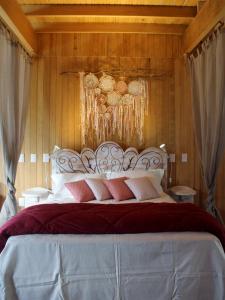 Un dormitorio con una cama grande con almohadas rojas y blancas. en Pousada dos Cataventos, en São Francisco de Paula