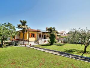 a house with palm trees in the yard at LOVRIĆ house with apartments in Umag
