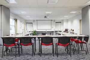 une salle de conférence avec une table et des chaises dans l'établissement Kyriad Clermont Ferrand Nord - Riom, à Riom