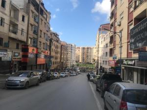 eine Stadtstraße mit am Straßenrand geparkt in der Unterkunft Coquelicot Tizi ouzou in Tizi Ouzou