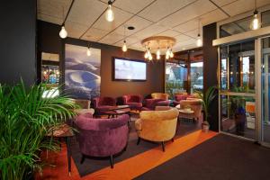 a lobby with a bunch of chairs and tables at Kyriad Clermont Ferrand Nord - Riom in Riom